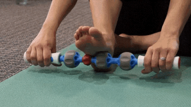 a person is using a massage roller on their foot