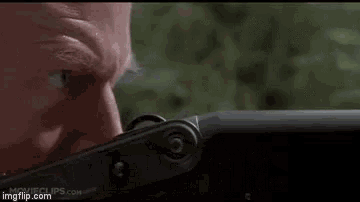 a man is holding a gun with the words `` clever girl '' written above him .