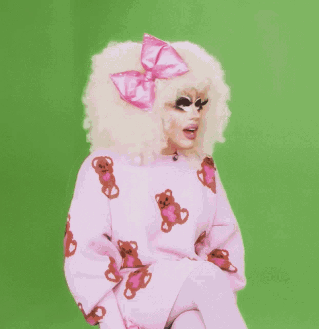 a woman wearing a pink sweater with teddy bears and a pink bow