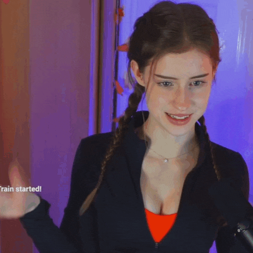 a woman stands in front of a microphone with a purple background and the words rain started below her