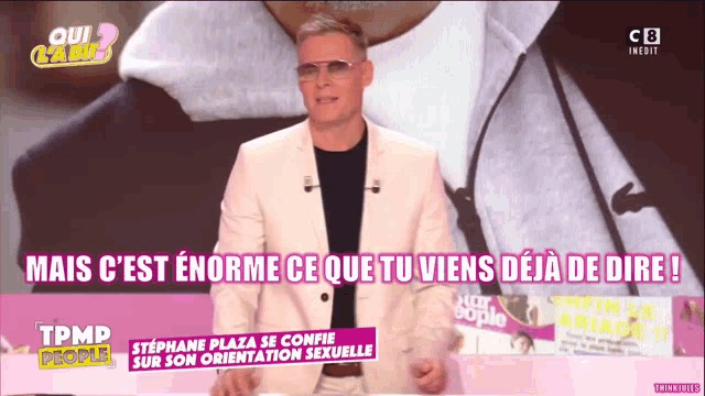 a man in a white suit stands on a tpmd people show