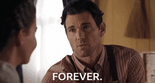 a man in a striped shirt is talking to a woman and the word forever is on the screen behind him