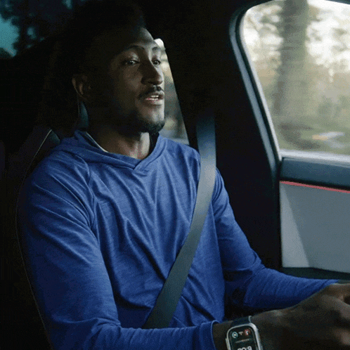 a man wearing a blue shirt is sitting in a car