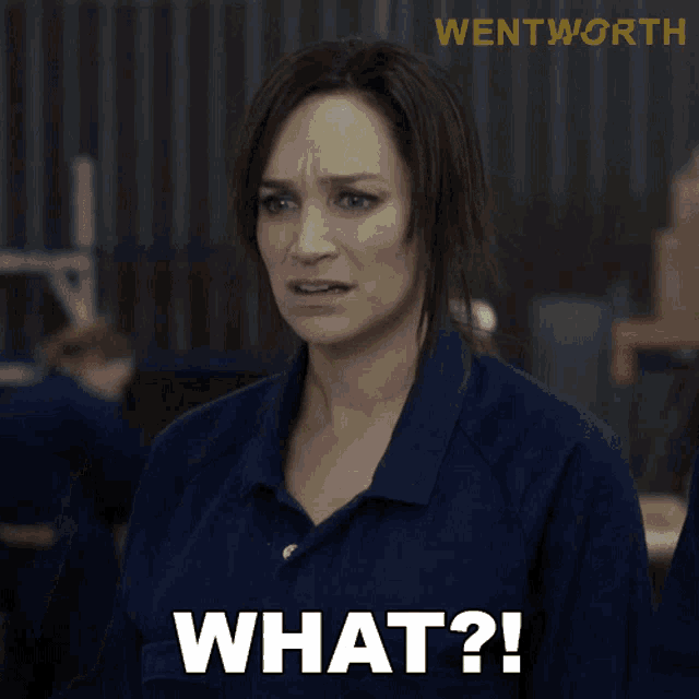 a woman in a blue shirt has the word what written on her face