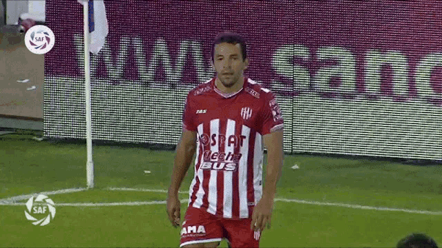 a soccer player wearing a red and white striped shirt that says seat leche bus on it