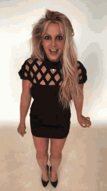 a woman in a black dress and heels is dancing