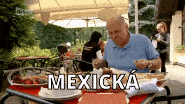 a man sits at a table with plates of food and the word mexicka written on it