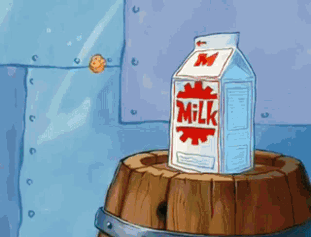 a carton of milk sits on a wooden barrel .