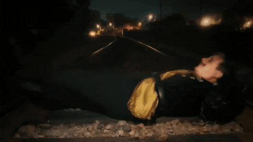 a person in a superhero costume is laying on a train track at night