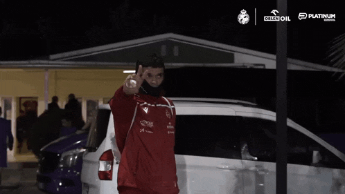 a man wearing a mask stands in front of a white van that says orlen oil on it