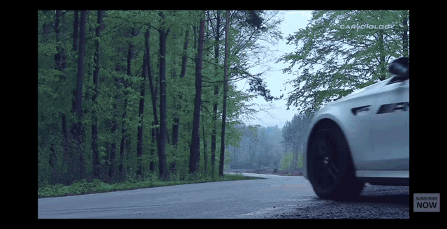 a car is driving down a road with a subscribe now button on the bottom of the screen