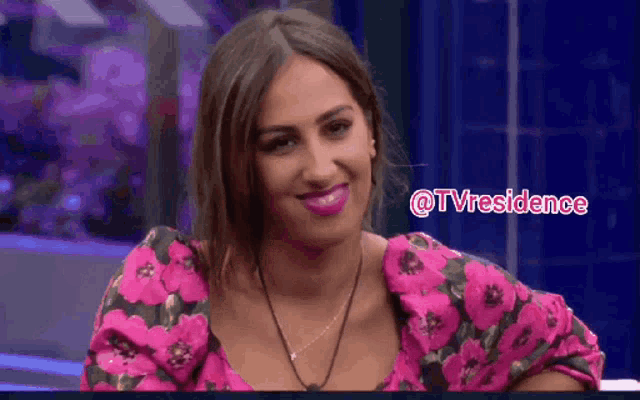 a woman in a pink floral top is smiling and the words @tvresidence are above her
