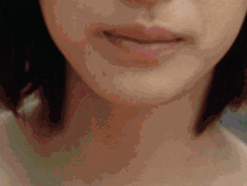 a close up of a woman 's face and neck with a blurred background