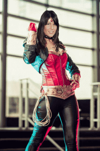 a woman in a wonder woman costume stands in front of a large window