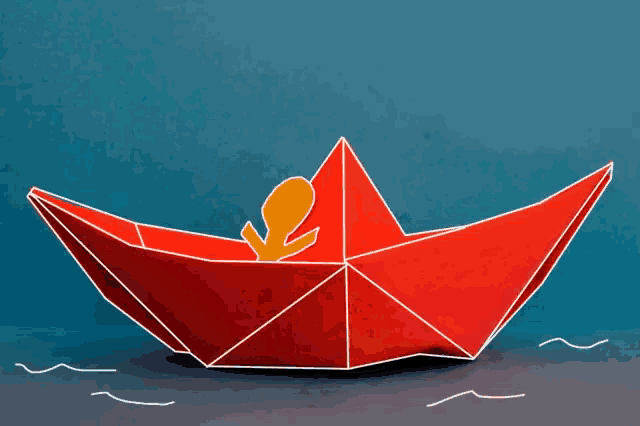 a red origami boat with a yellow silhouette of a person in it