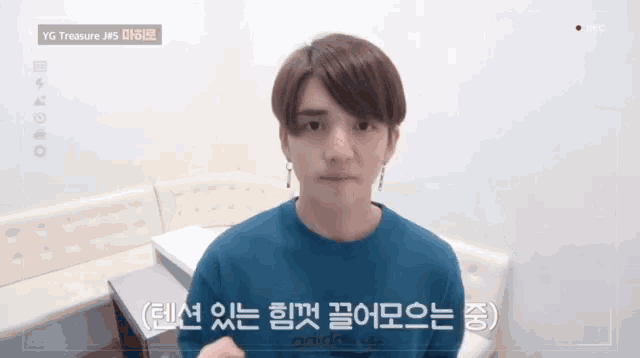 a young man wearing a blue adidas sweatshirt looks at the camera