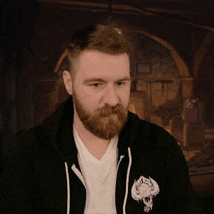 a man with a beard is wearing a black hoodie with a white logo on the back