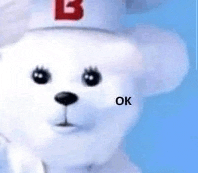 a white teddy bear wearing a white hat with the letter b on it is sitting on a blue surface .