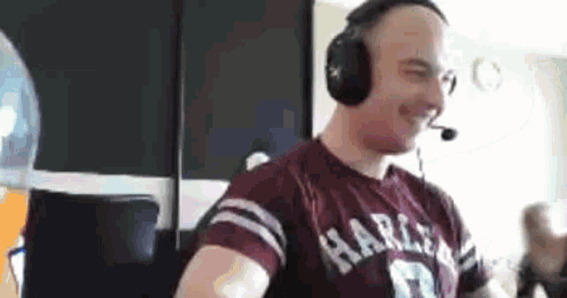a man wearing headphones and a harley davidson shirt is dancing .