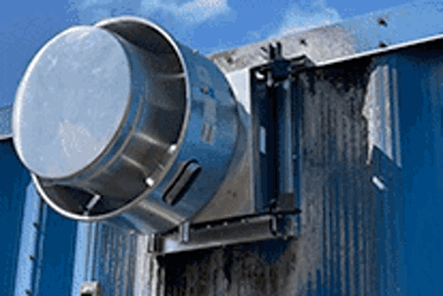 a metal object is attached to the side of a blue building .