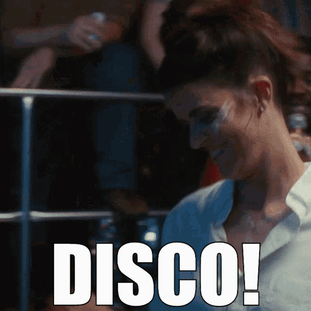a woman in a white shirt is smiling in front of a sign that reads disco