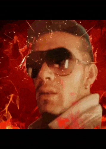 a man wearing sunglasses stands in front of a fire background