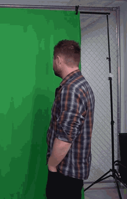 a man stands in front of a green screen