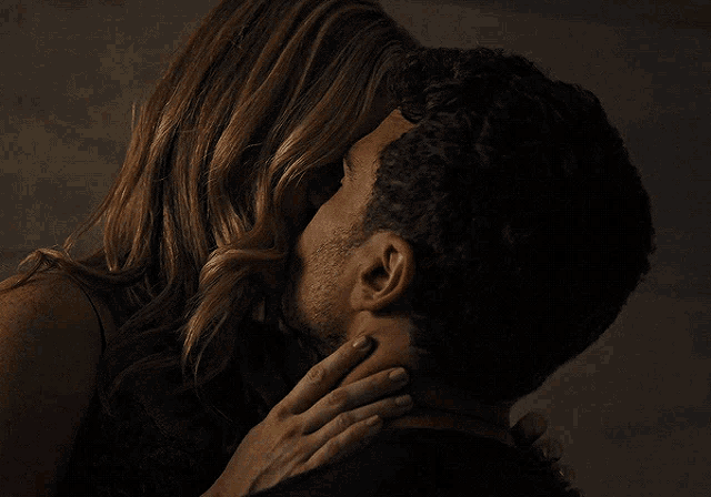 a man and a woman are kissing in the dark