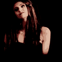 a woman with long hair is wearing a black top and a necklace .
