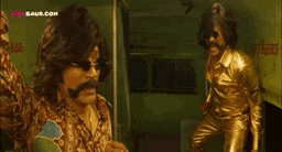 a man in a gold suit is standing next to another man .