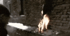 a person standing in front of a brick wall with a fire coming out of it .