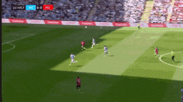 a soccer game is being played on a field with emirates ads on the sidelines