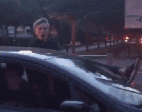 a blurry picture of a man in a car talking to someone
