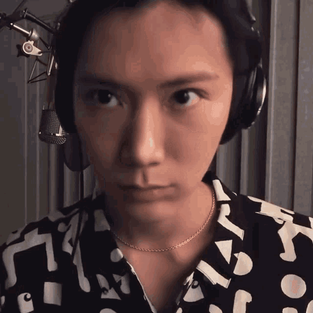 a close up of a person wearing headphones and a chain