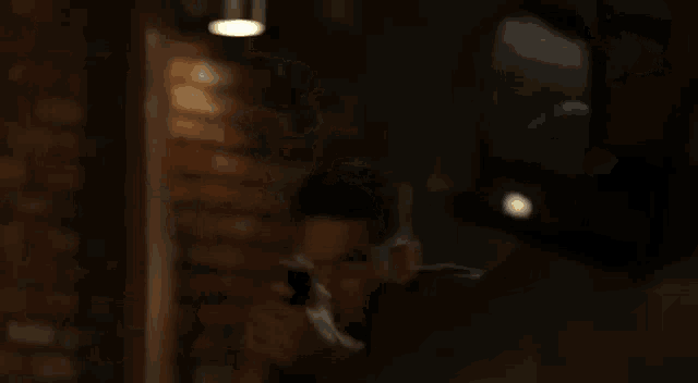 a man is pointing a gun at another man in a dark room in a blurry photo .