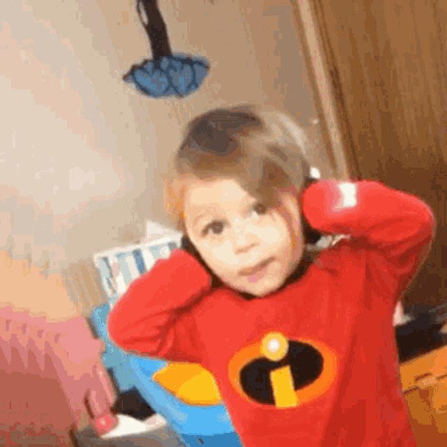 a little girl is wearing a red shirt with an i on it