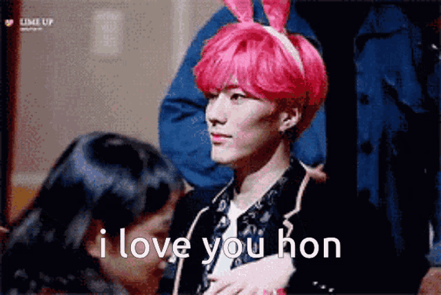 a man with pink hair wearing bunny ears says " i love you hon "