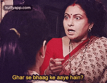 a woman in a red sari is talking to another woman in a movie .