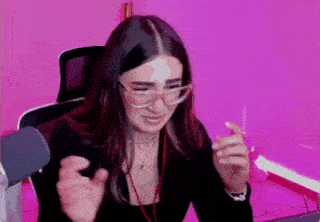 a woman wearing glasses and headphones is sitting in front of a laptop computer .