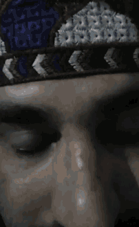 a close up of a man 's face with a blue and white headband