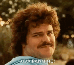 a man with curly hair and a mustache is smiling and making a funny face .