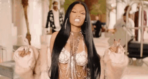 a woman with long black hair is wearing a bra and a fur coat and making a funny face .
