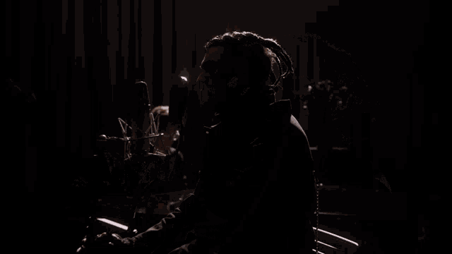 a man singing into a microphone with a tattoo on his face