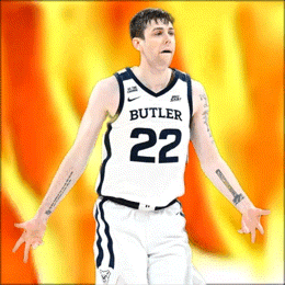 a basketball player with the number 22 on his jersey stands with his arms outstretched