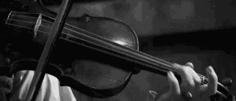 a woman is playing a violin in a black and white photo .