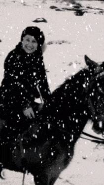 a woman riding a horse in the snow