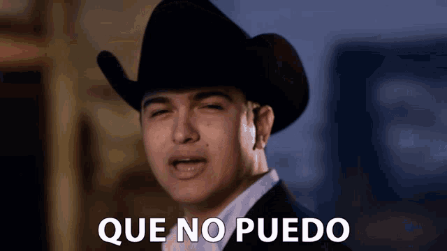 a man wearing a cowboy hat with que no puedo written below him