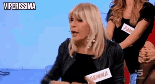 a woman in a black jacket has a name tag that says gemma on it