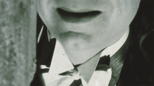 a black and white photo of a man wearing a bow tie and tuxedo
