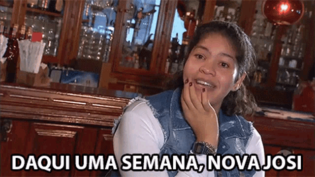 a woman sitting at a bar with the words daqui uma semana nova josi written below her